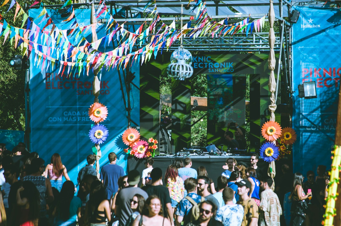 Folla che si diverte a un festival musicale all'aperto con un DJ sul palco.