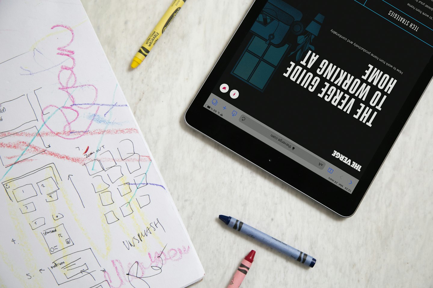 Un tablet e un taccuino di design sono su una scrivania.